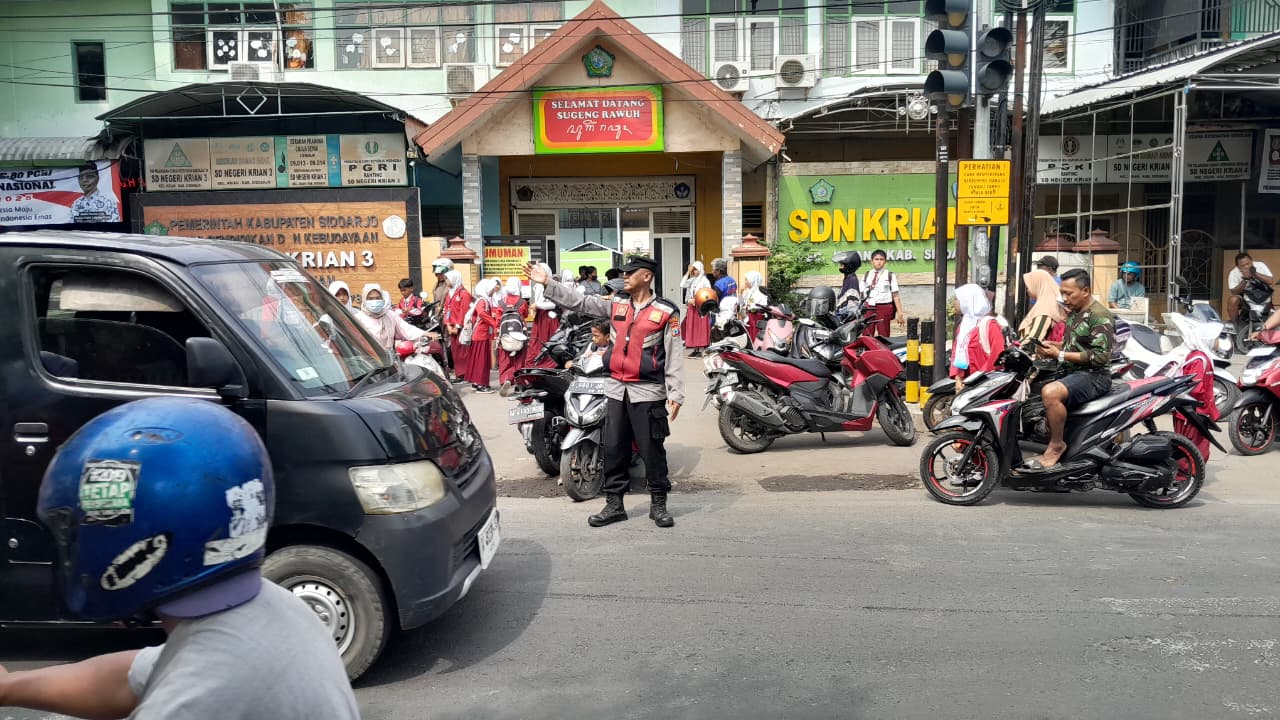 Peduli Keselamatan Pelajar, Polsek Krian Atur Lalin dan Bantu Penyeberangan di Depan Sekolah