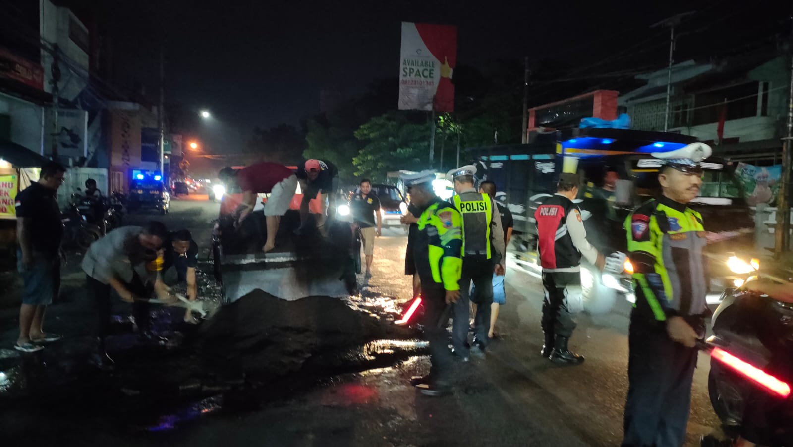 Polisi dan Relawan Tambal Jalan Rusak