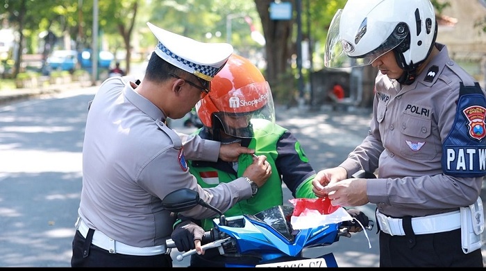 Satlantas Polres Gresik Bagikan Bendera dan Pin Merah Putih di GKB, Tanamkan Semangat Kemerdekaan