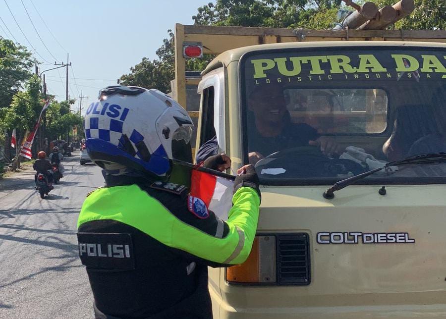Semarak Kemerdekaan, Polsek Rungkut Bagikan Bendera Merah Putih kepada Warga Surabaya