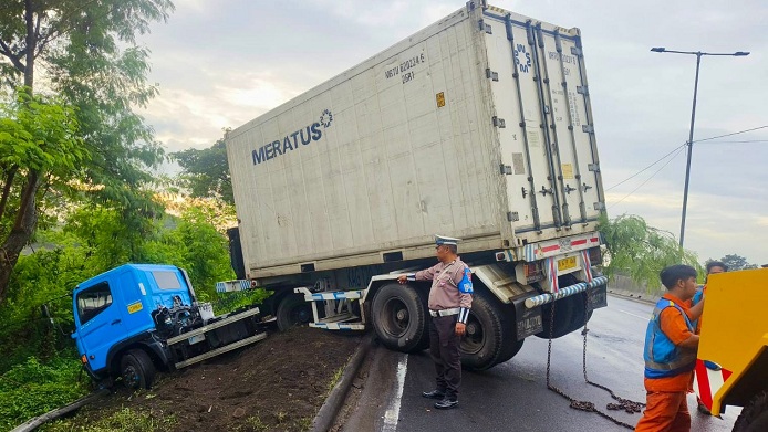 Ban Selip, Truk Kontainer Nyungsep di Parit Tol Satelit Surabaya