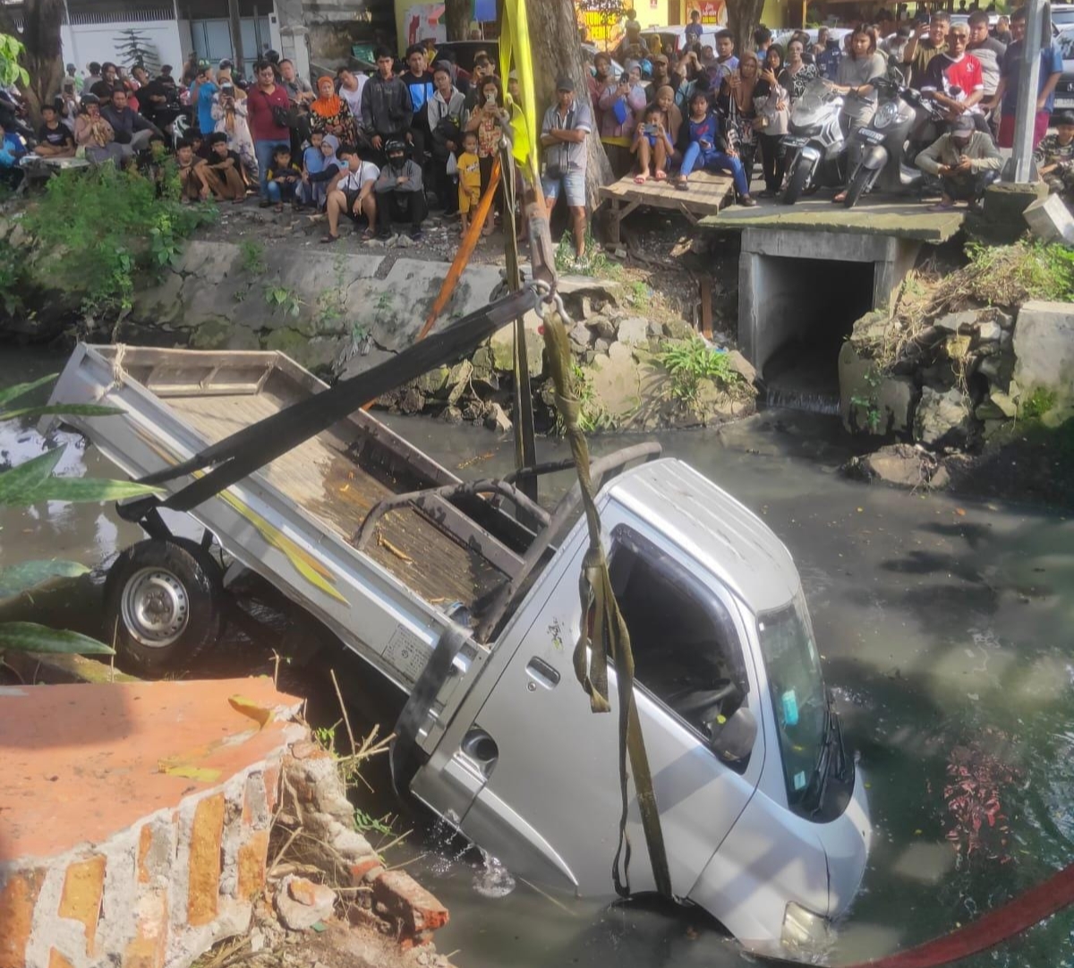 Disenggol Mobil, Pikap Gran Max Tercebur Sungai Penjaringan Asri