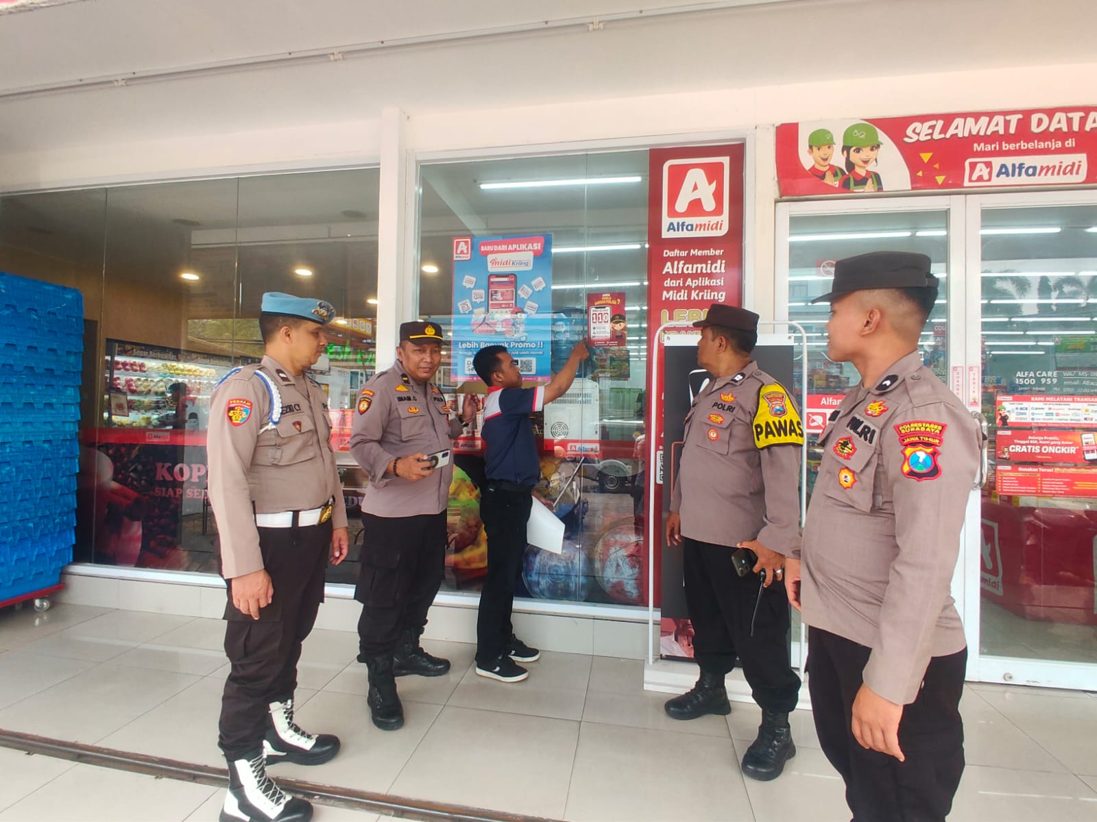 Polsek Sukomanunggal Pasang Stiker Layanan Darurat Halo Polisi 110 di Minimarket