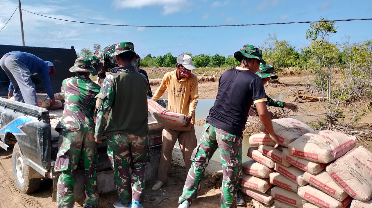 Anggota Satgas TMMD Ke-121 Kodim 0827/Sumenep Bersama Warga Menurunkan Material Semen