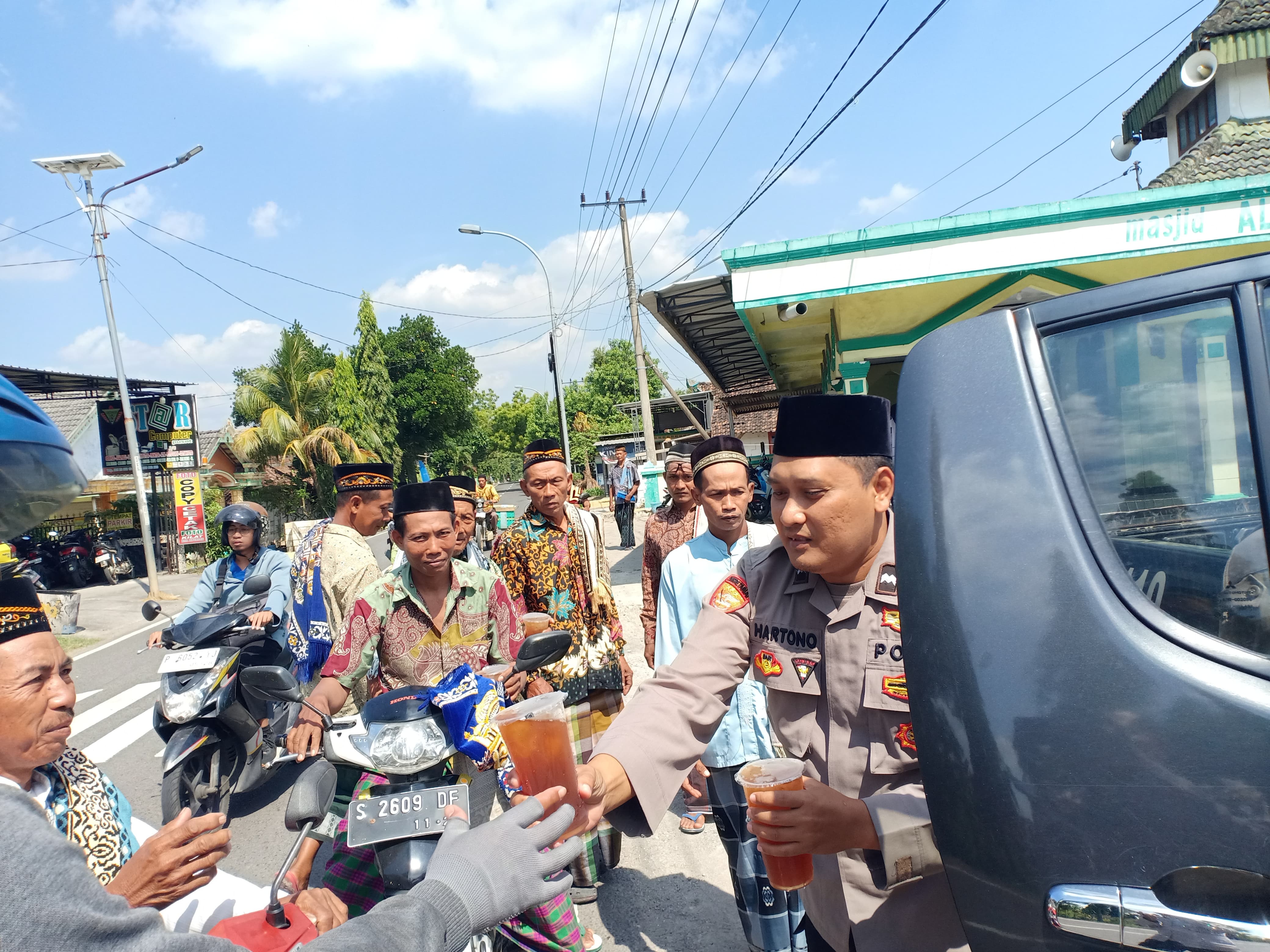 Cuaca Panas, Polsek Temayang Bagikan Es Teh ke Warga Seusai Salat