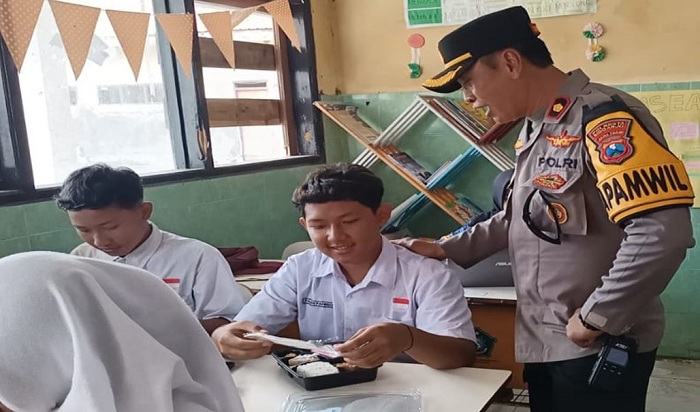 Naik Perahu, Kapolsek Buduran Bagikan Makan Siang Bergizi di Sekolah Wilayah Terpencil