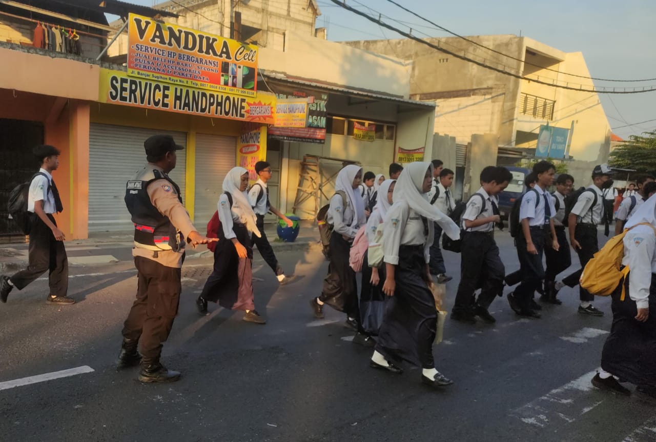 Bhabinkamtibmas Polsek Tandes Sigap Bantu Siswa Menyeberang di Depan SMPN 26