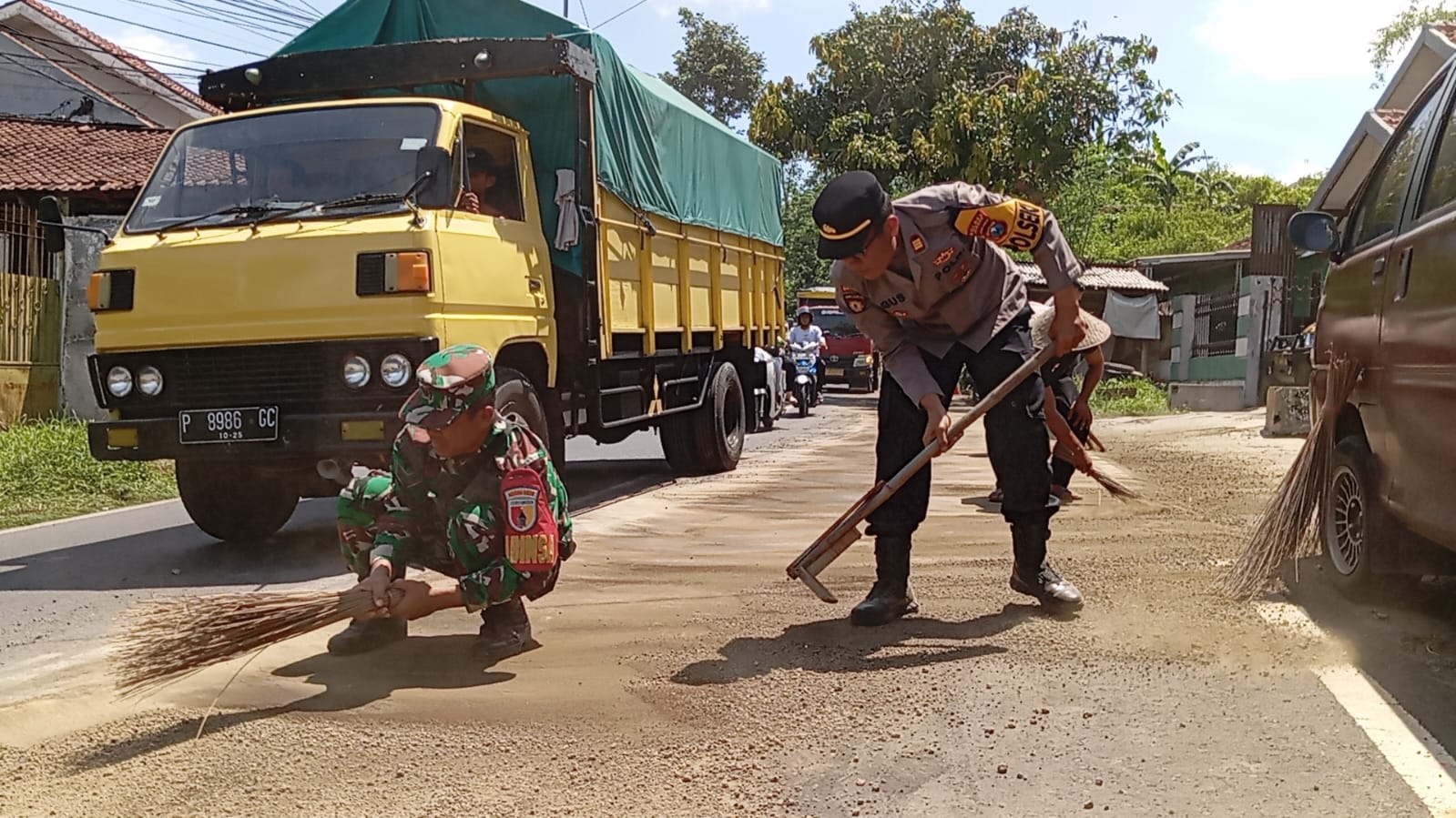 Polsek dan Koramil Sukorambi Kompak Bersihkan Tumpahan Oli di Jalan Mujahir