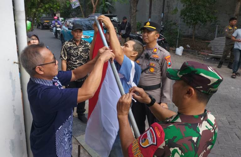 Kapolsek Tenggilis Mejoyo Bersama Tiga Pilar Bagikan Bendera Merah Putih, Tumbuhkan Semangat Patriotisme