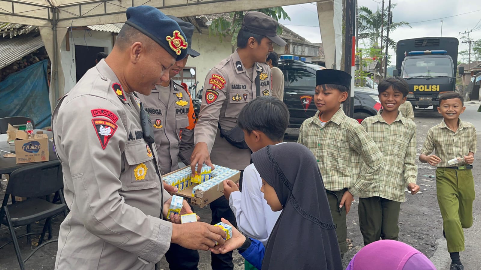 Brimob Polda Jatim dan Polres Lumajang Bagikan Snack dan Susu untuk Anak-Anak Terdampak Erupsi Semeru