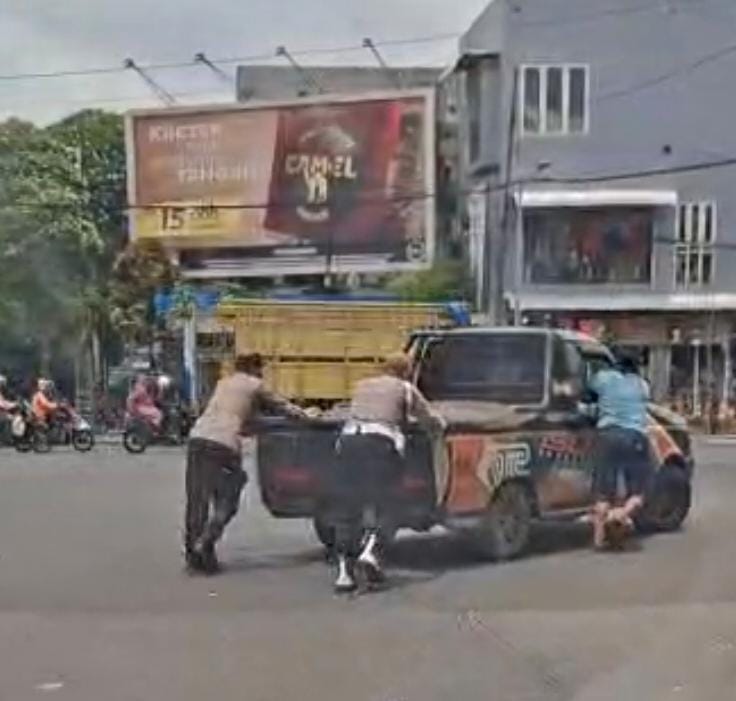 Personel Polsek Bubutan Bantu Dorong Mobil Mogok di Tengah Terik Matahari