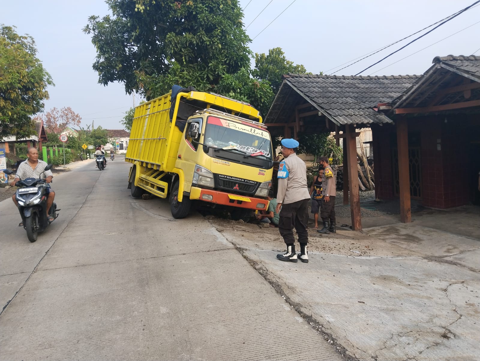 Anggota Polsek Bubulan Bantu Evakuasi Truk Terperosok di Bahu Jalan