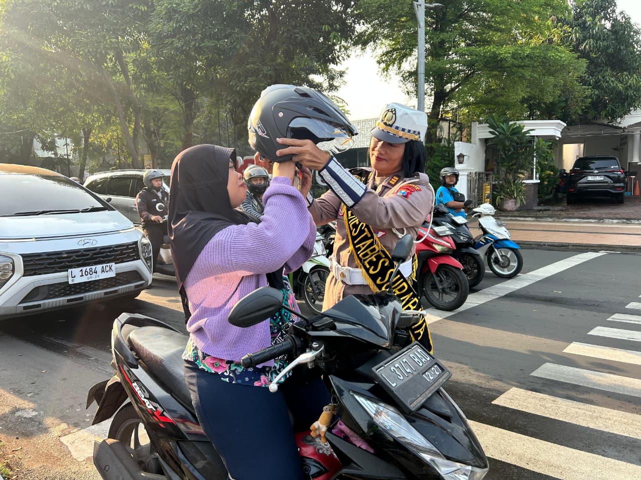 Peringatan Hari Kartini, Satlantas Polrestabes Surabaya Berbagi Helm dan Coklat di Jalan