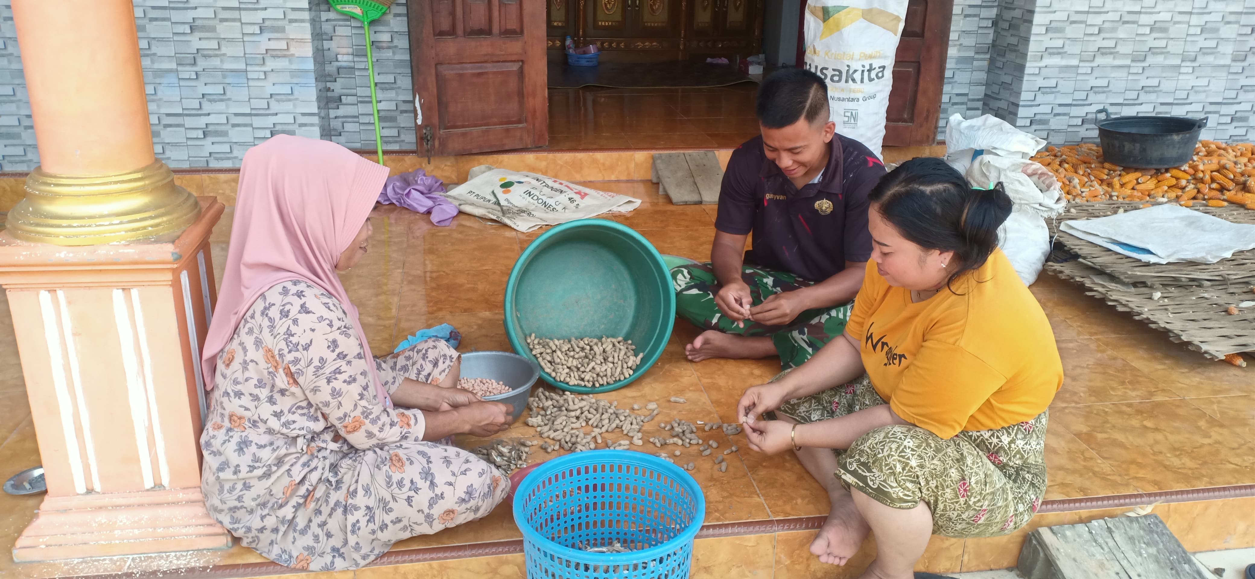 Membaur dengan Warga, Satgas TMMD Kodim 0827/Sumenep Bantu Kupas Kacang Tanah Hasil Panen