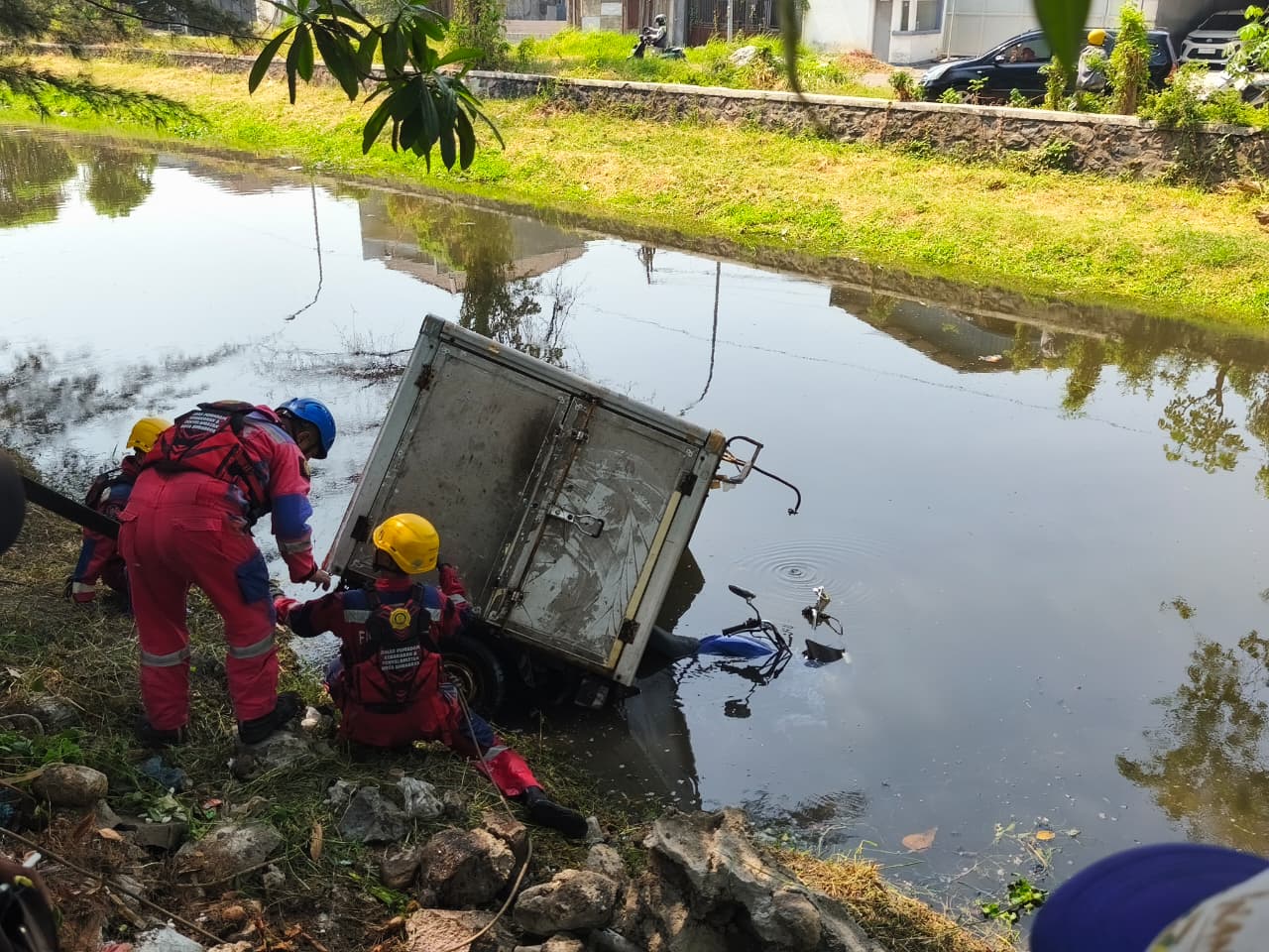 Hilang Kendali, Motor Roda Tiga Operasional J&T Terjun ke Parit Medokan Sawah Timur