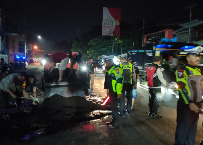 Polisi dan Relawan Tambal Jalan Rusak