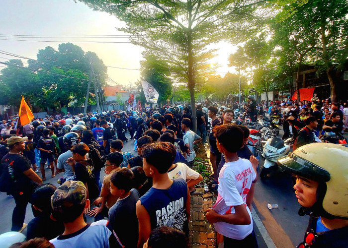 Ribuan massa PSHT arus bawah memadati Jalan Teuku Umar, Surabaya, saat mendatangi markas debt collector (DC) dengan pengawalan ketat aparat kepolisian. (Foto: Oskario Udayana)
