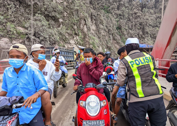 Satlantas Polres Lumajang Bagikan Masker Pasca Erupsi Semeru di Jembatan Besuk Kobokan