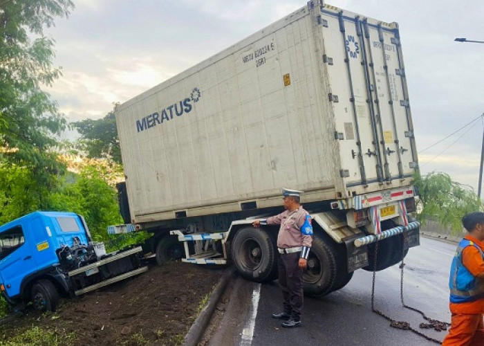 Ban Selip, Truk Kontainer Nyungsep di Parit Tol Satelit Surabaya