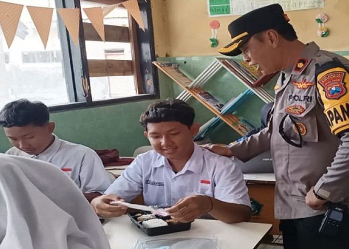 Naik Perahu, Kapolsek Buduran Bagikan Makan Siang Bergizi di Sekolah Wilayah Terpencil