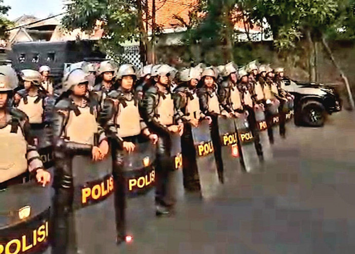 Aparat kepolisian bersiaga membentuk barikade di Jalan Pandegiling, Tegalsari, Surabaya guna mengantisipasi massa PSHT arus bawah yang berupaya masuk ke lokasi markas DC. (Foto: Oskario Udayana)
