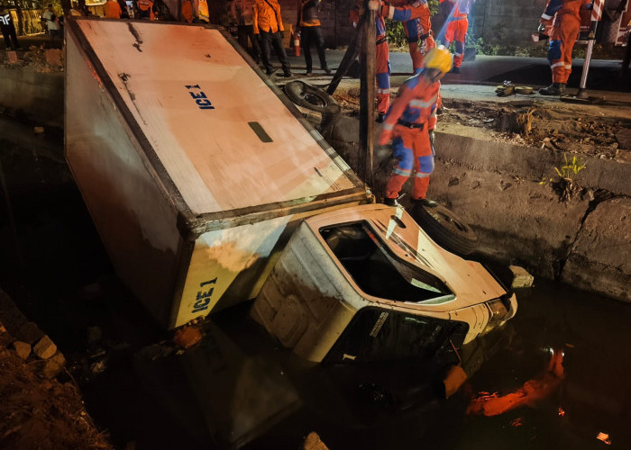 Truk Boks Es Kristal Masuk Parit di Gayung Kebonsari, Petugas Damkar Diterjunkan