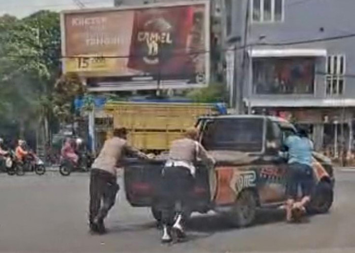 Personel Polsek Bubutan Bantu Dorong Mobil Mogok di Tengah Terik Matahari