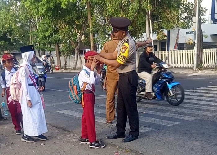 Bhabinkamtibmas Krembangan Selatan Bantu Penyeberangan Siswa dan Jadi Inspektur Upacara