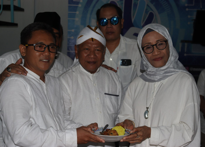 Pemred Memorandum Sujatmiko menerima potongan tumpeng dari Komisaris Utama Prof Mangestuti Agil.