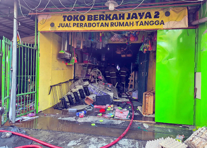 Selang dan genangan air berserakan saat petugas memadamkan kebakaran dua toko di Jalan Putat Jaya Sekolahan, Banyu Urip, Sawahan, Surabaya, Rabu (29/7) pagi.
