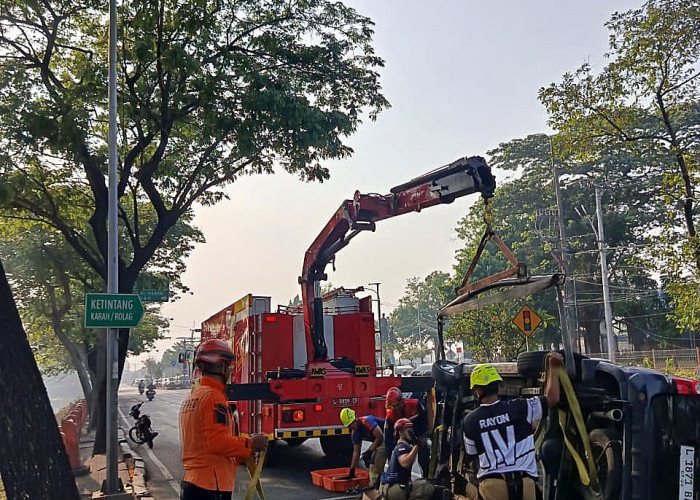 Tim gabungan mengevakuasi mobil Toyota Avanza yang terbalik dan tersangkut di pembatas jalan di Gunungsari, Surabaya.  (Foto: Oskario Udayana)