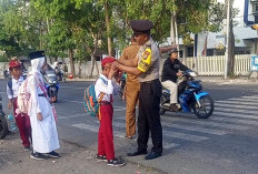 Bhabinkamtibmas Krembangan Selatan Bantu Penyeberangan Siswa dan Jadi Inspektur Upacara