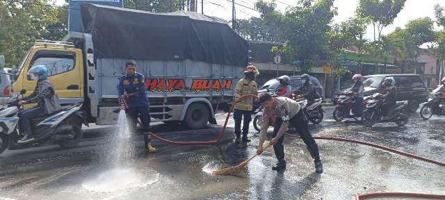 Cegah Kecelakaan, Satlantas Bojonegoro dan Damkar Bersihkan Material Cor di Jalan